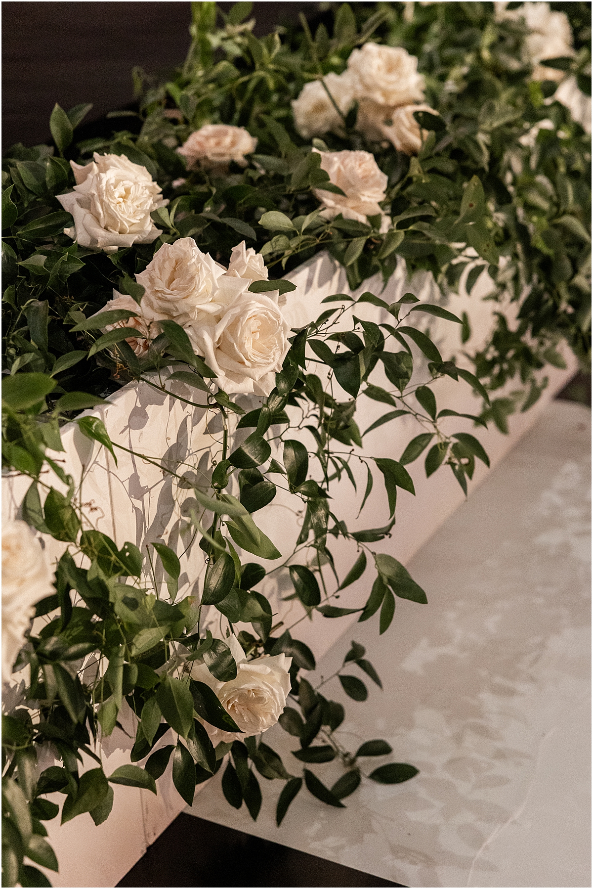 white roses in greenery 