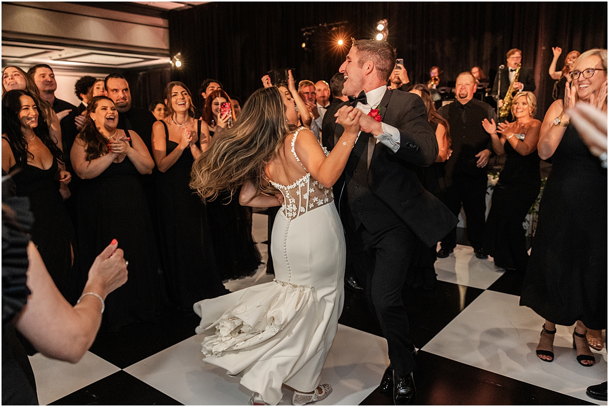 guests surround bride and groom as they dance 